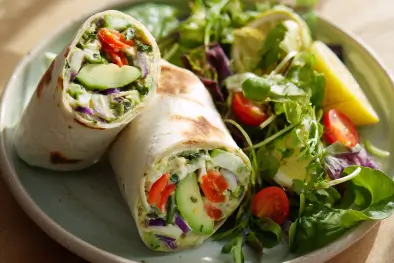 Fresh Hummus & Avocado Wrap cut in half showing colorful vegetables and creamy hummus