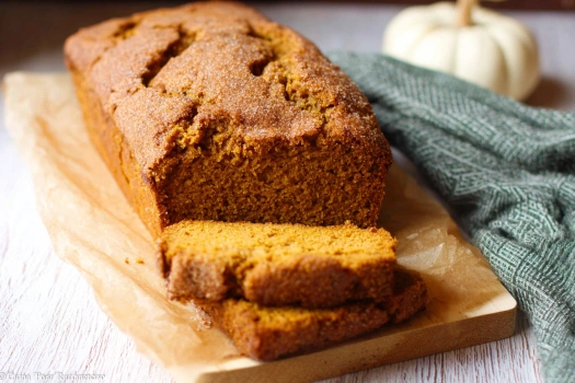 Gluten free cinnamon pumpkin bread sliced on wooden board with cinnamon sugar topping
